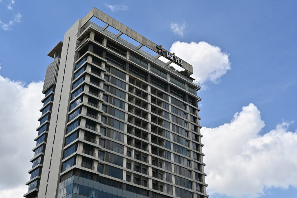 Fassade eines mehrstöckigen Bürogebäudes aus Glas und Beton mit Eingangsbereich und Vorplatz