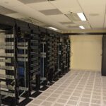 Reihen von Serverschränken in einem Rechenzentrum mit blinkenden Statusleuchten und Kabelführungen