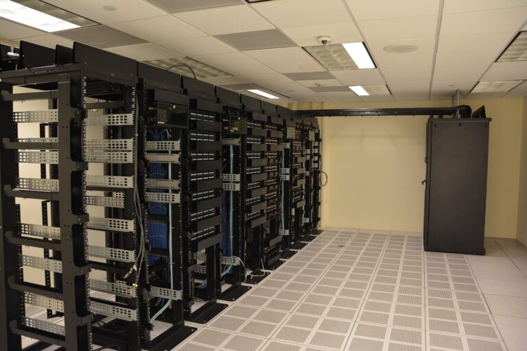Reihen von Serverschränken in einem Rechenzentrum mit blinkenden Statusleuchten und Kabelführungen