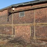 Werkbank in einer Tischlerei mit Handwerkzeug, Spänen und Holzbrettern an der Wand