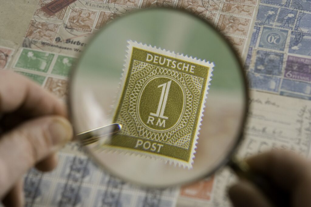 Lupe über einer eng bedruckten Vertragsseite mit nummerierten Absätzen