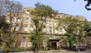 Die steinerne Fassade eines Bankgebäudes mit hohen Fenstern und schwerem Eingangsportal