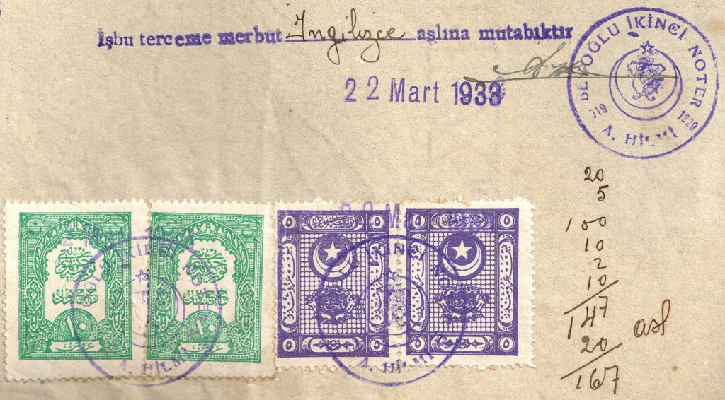 Ein Stempel und ein geheftetes Dokument liegen auf einem dunklen Schreibtisch