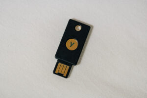 Ein kleiner Sicherheitsschlüssel mit USB-Stecker liegt neben einer Laptoptastatur