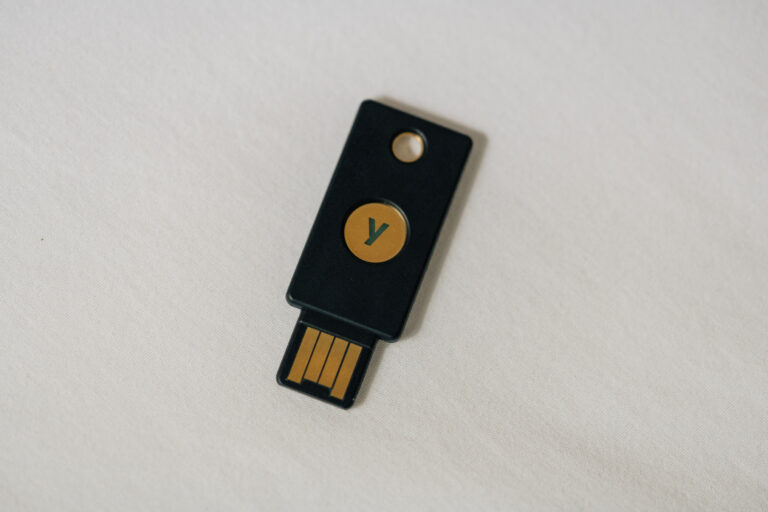 Ein kleiner Sicherheitsschlüssel mit USB-Stecker liegt neben einer Laptoptastatur