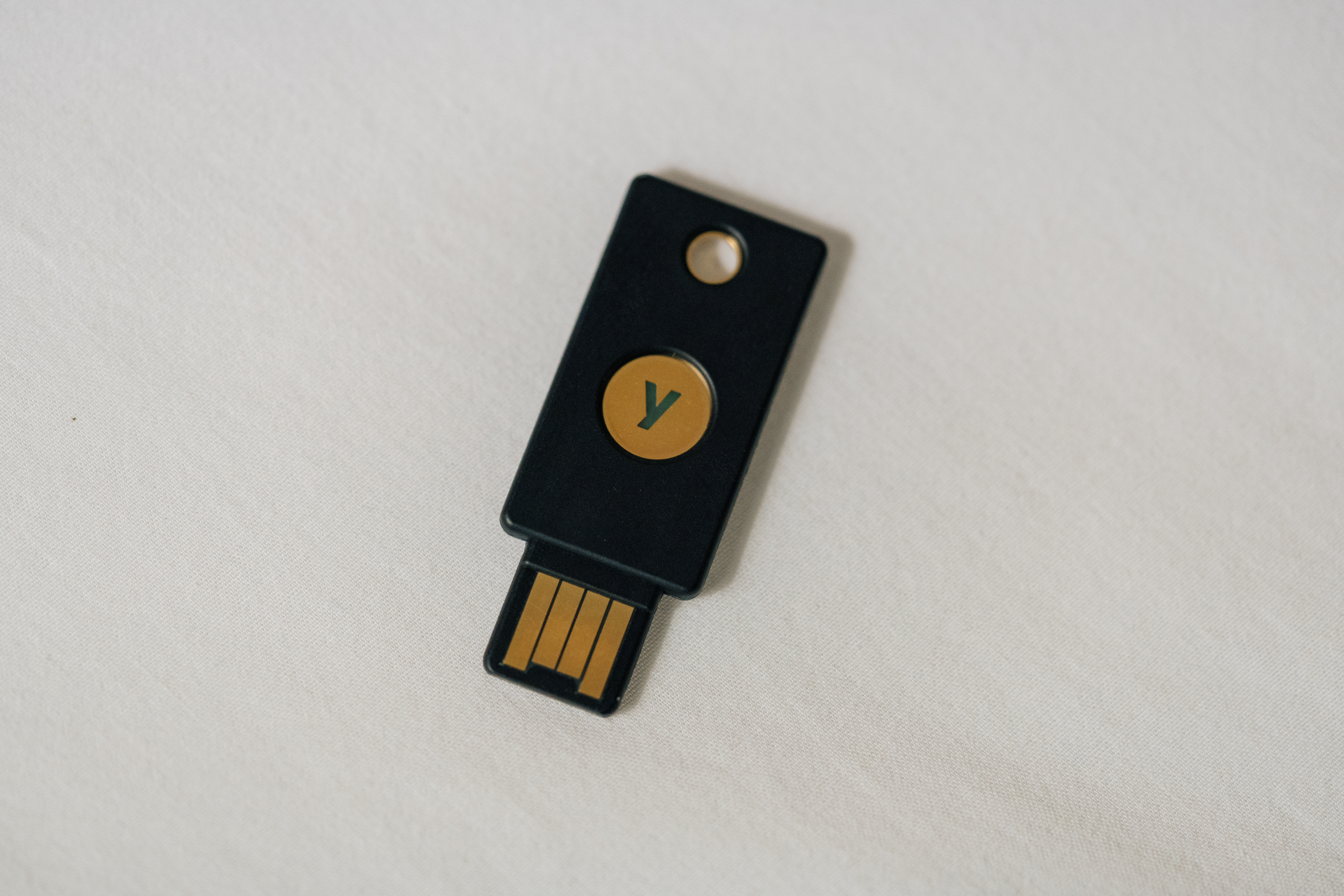 Ein kleiner Sicherheitsschlüssel mit USB-Stecker liegt neben einer Laptoptastatur