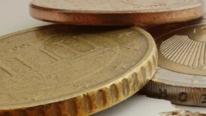 Mehrere unterschiedlich hohe Münzstapel stehen nebeneinander auf einer dunklen Tischplatte